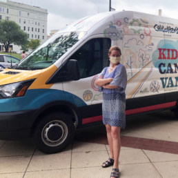 Maggie Lancaster, GRCM CEO, in front of the van.