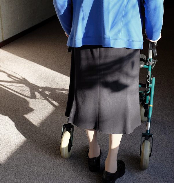 Elderly woman walking way form camera